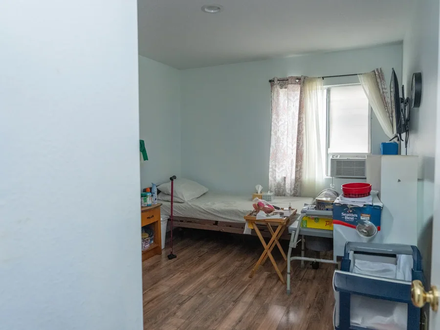 Resident bedroom with single bed, window, and personal storage areas.