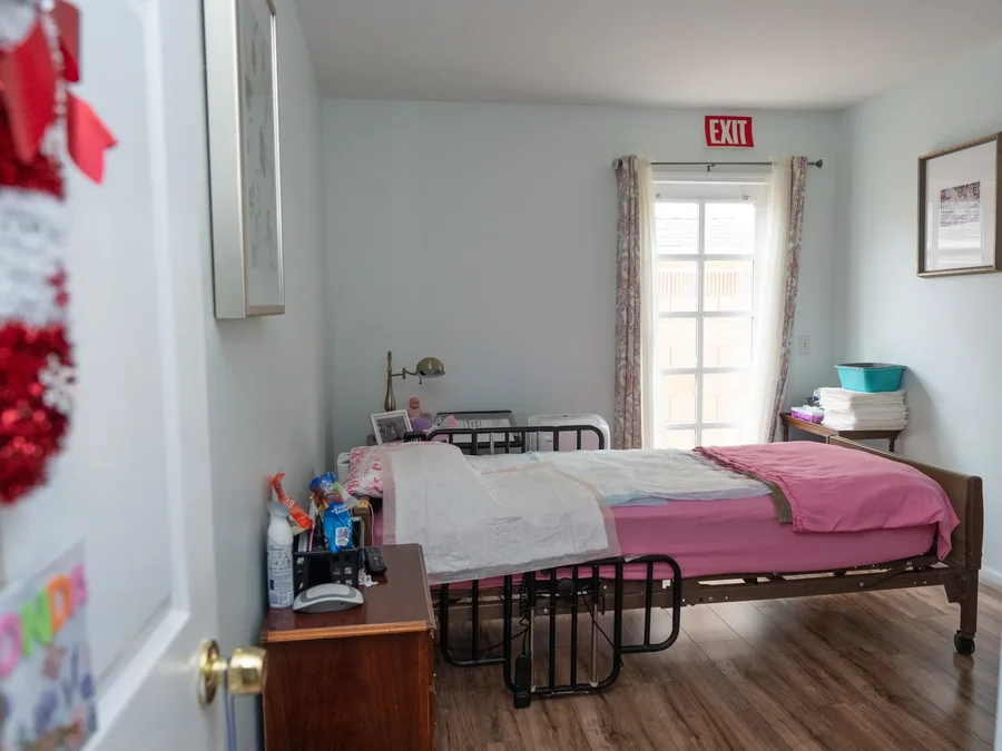 Spacious accessible bedroom with hospital bed and bright natural lighting.