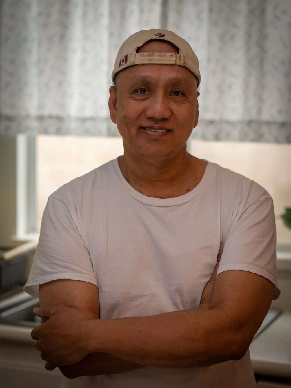 Friendly caregiver smiling in residential care facility interior.
